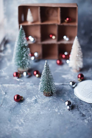 Make The Holidays Special With A Snowy Miniature Christmas Tree Wallpaper