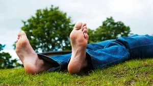 Male Lying On The Grass Showing Bare Feet Wallpaper