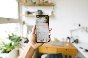 Man Checking Notifications On Mobile Phone Wallpaper