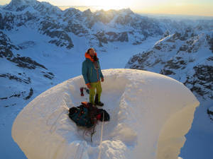 Man Conquering Mountain Peak Wallpaper