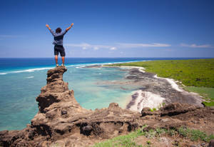 Man On Cliff Plage Gountsini Comoros Wallpaper