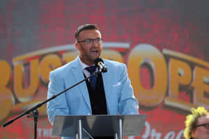 Man Speakingat Podium Wallpaper