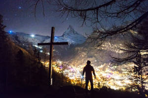 Man Standing Near Cross During Night Wallpaper