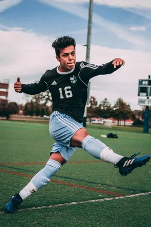 Man Wearing Black And Blue Jersey Shirt On Field Wallpaper