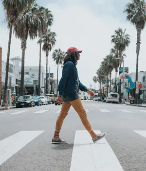Man Wearing Red Cap Crossing Street Wallpaper