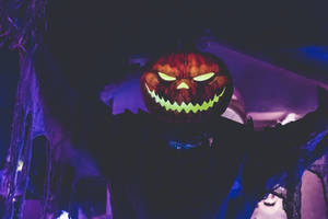 Man With Smiling Dark Pumpkin Head For Halloween Wallpaper