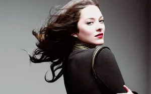 Marion Cotillard Stands Side-ways In Captivating Elegance. Wallpaper