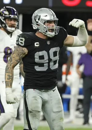 Maxx Crosby Flexing Against Baltimore Ravens Wallpaper
