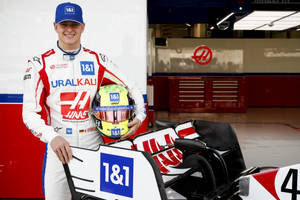 Mick Schumacher Beside A Racing Car Wallpaper