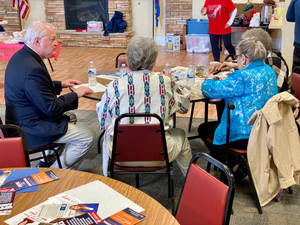 Mike Gibbons Sitting With Senior Citizens Wallpaper