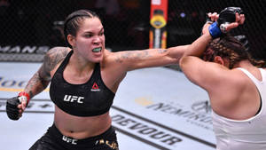 Mma Fighter Amanda Nunes Unleashing A Punch Wallpaper