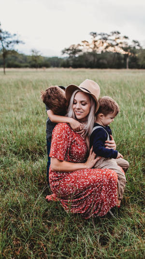 Mom And Son Hugging In Fields Wallpaper