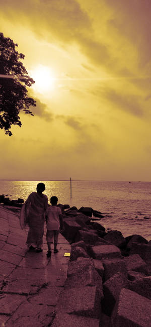 Mom And Son Walking By The Beach Wallpaper