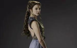 Natalie Dormer Striking A Pose Against A Light Blue Background Wallpaper