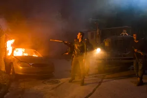 Negan Standing Next To Flaming Car Wallpaper