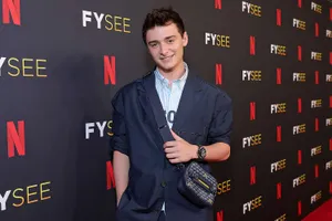 Noah Schnapp With Suit And Sling Bag Wallpaper