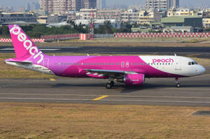 Peach Aviation Airplane On Runway Wallpaper
