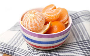 Peeled And Unpeeled Clementine Fruits In Bowl Wallpaper