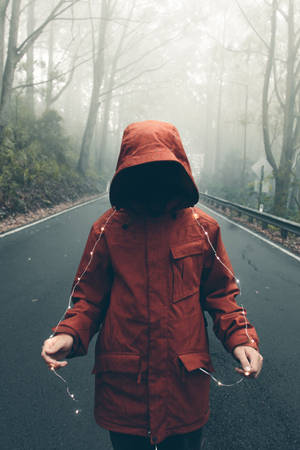 Person In Red Hooded Jacket Holding String Lights Wallpaper