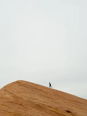 Person Running On Top On Hill During Daytime Wallpaper