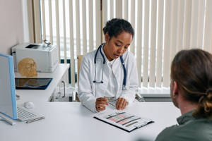 Physician Writing Down Diagnosis Wallpaper