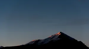 Picturesque Mountain Range With Clouds And The Horizon Beyond Wallpaper