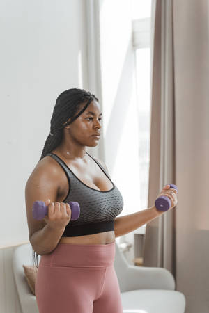 Plus Size Woman Exhibits Strength In Fitness Wallpaper