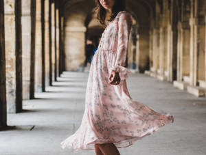 Pose Perfectly - A Fashion Model Perfects Her Look In A Pink Dress Wallpaper