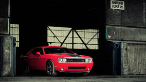 Power Unleashed - Stark Red Dodge Challenger Parked In Garage. Wallpaper