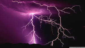 Powerful Purple Lightning Illuminates The Night Sky Wallpaper