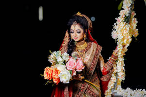 Radiant Indian Bride Holding A Bouquet At Her Wedding Wallpaper