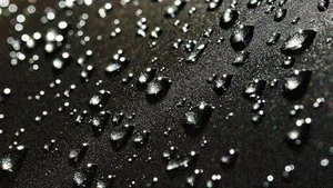 Raindrops Falling On A Deep Black Surface Wallpaper