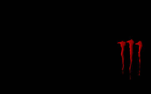 Red Monster Logo On A Minimalistic Black Background Wallpaper