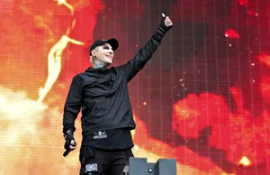 Rock Performeron Stagewith Red Backdrop Wallpaper