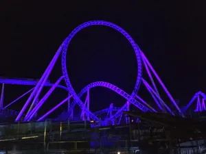 Roller Coaster In Neon Purple Color Wallpaper