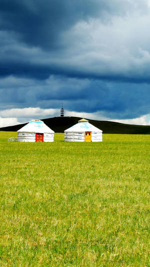 Scenic View Of Traditional Mongolian Yurts On Vast Plains Wallpaper