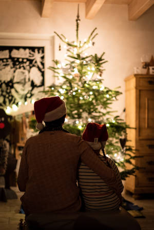 Selective Focus Photography Of Girl An Woman Hugging Each Other In Front Of Christmas Tree Wallpaper