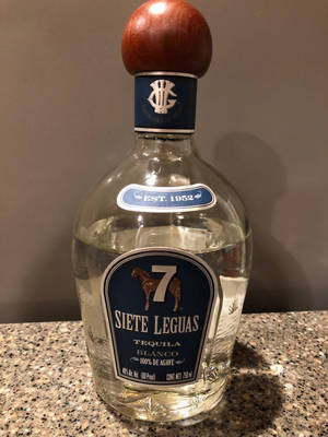 Siete Leguas Blanco Tequila Bottle Glistening In Light Wallpaper