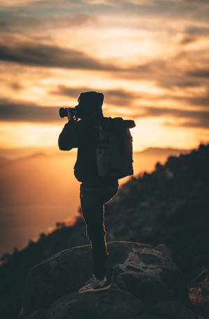 Silhouette Of Man Holding Camera During Sunset Wallpaper