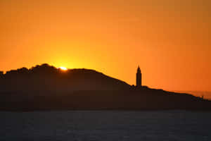 Silhouette Of Tower Of Hercules Orange Sunset Wallpaper