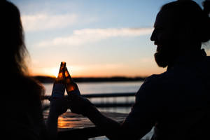 Silhouette Photography Of Man And Woman Carrying Beer Bottles Wallpaper