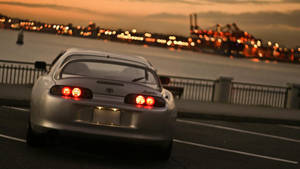 Silver Toyota Supra Near Cityscape Wallpaper