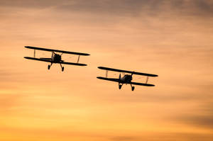 Small Planes In Sunset Sky Wallpaper