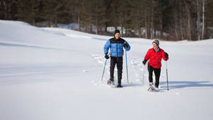 Smiling Couple In Snowshoes Wallpaper