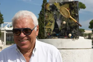 Smiling_ Man_with_ Sunglasses_and_ Tennis_ Memorabilia_ Background Wallpaper