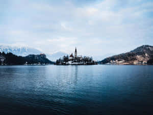 Snow-kissed Julian Alps Encircling Pristine Lake Bled Wallpaper