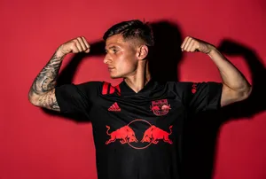 Soccer Player Flexingin Red Bull Jersey Wallpaper