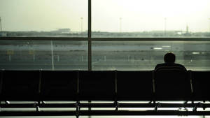 Solitary Man Waiting At Airport Lounge Wallpaper