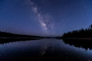 Starry Night Sky Over A River Wallpaper