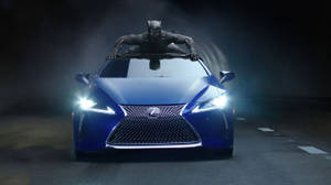 Striking Blue Lexus Underneath The Shadow Of The Black Panther Wallpaper